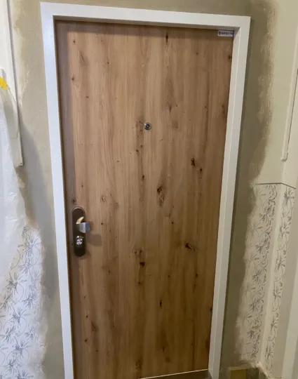 Bezpečnostní dveře SECUM po montáži, dřevodekor se suky a bílou zárubní