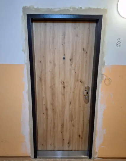 Bezpečnostní dveře SECUM po montáži, světlý dřevodekor se suky, pohled z chodby