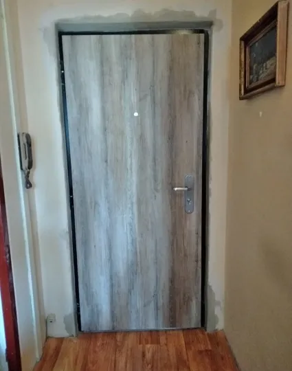 Bezpečnostní dveře SECUM po montáži, šedý dřevodekor, pohled z bytu