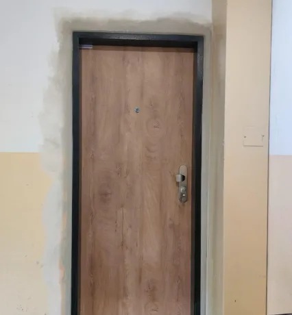 Bezpečnostní dveře SECUM po montáži, světlý dřevodekor, pohled z chodby